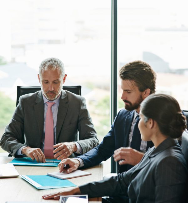 Lets review the contract details...Shot of a group of executives having a meeting in a boardroom.